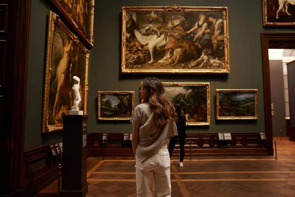 A visitor viewing paintings in a museum