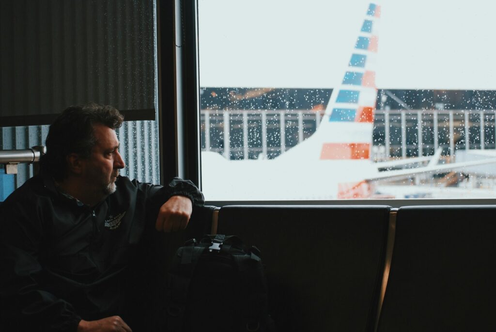 Traveler in an airport lounge watching a plane