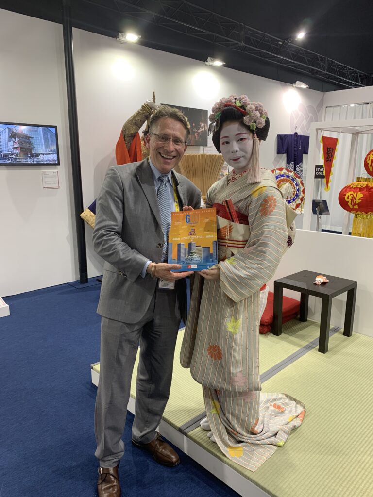 The Group of Nations G20 Japan publication presented alongside a guest in traditional kimono, G20 Osaka 2019